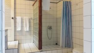 a bathroom with a shower, toilet, and sink at Playa Negra Guesthouse in Cahuita