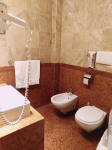a bathroom with a white toilet and a sink at Hotel Columbus in Lignano Sabbiadoro