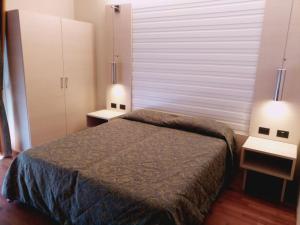 um quarto com uma cama, 2 candeeiros e uma janela em Hotel Columbus em Lignano Sabbiadoro