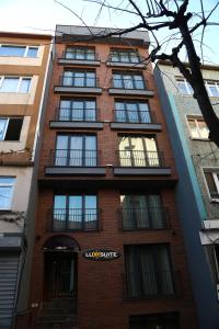 ein hohes rotes Backsteingebäude mit Fenstern in der Unterkunft Luxx Suite Nişantaşı in Istanbul
