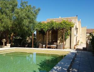a swimming pool in front of a house at Masseria Sucéa in Martano