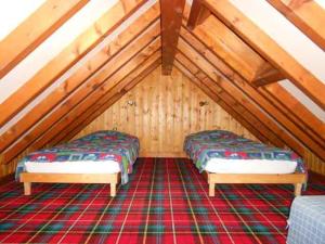 two beds in a attic room with wooden ceilings at Résidence du Chajoux in La Bresse