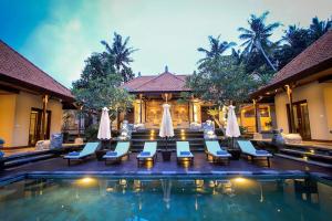- une piscine avec des chaises longues et un complexe dans l'établissement Villa Heron Ubud, à Ubud