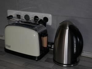 a toaster and a tea kettle on a counter at Ferienwohnung im Neubauernweg 3 in Hoppegarten