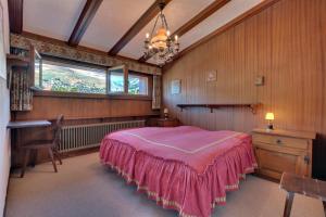 a bedroom with a pink bed and a window at Rouet 12 in Verbier