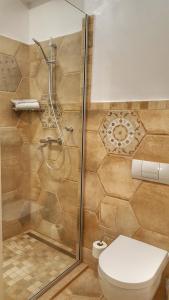 uma casa de banho com um chuveiro e um WC. em Windmill Studios by Rembrandt Hotel em Bucareste