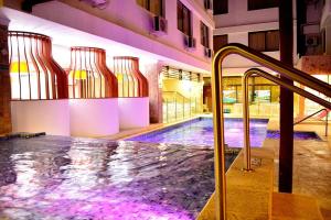 a indoor swimming pool in a building with a pooliteratoriteratorythonythonythonython at Hotel La Riviera in Santa Marta