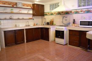 a kitchen with wooden cabinets and a white stove top oven at NUESTRA CASA - OUR HOME Cuenca by A2CC in Ricaurte