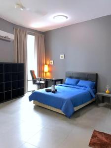 1 dormitorio con cama azul y escritorio en Empire Damansara Residence Suites en Petaling Jaya