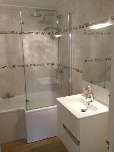 a bathroom with a shower and a sink and a tub at 5, Sandleigh Apartment in Woolacombe