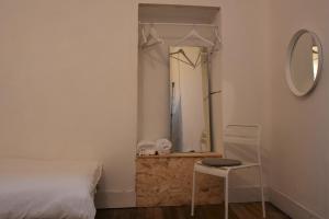 a bathroom with a bed and a mirror at Slow City Hostel Pontevedra in Pontevedra