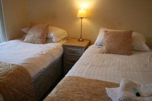 een slaapkamer met 2 bedden en een lamp op een nachtkastje bij The Angel Inn (Blyth) in Blyth
