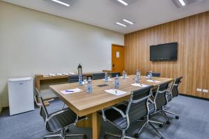 a conference room with a large wooden table and chairs at Comfort Mogi Guaçu in Mogi Guaçu
