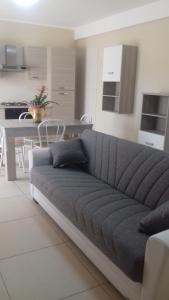 a gray couch in a living room with a kitchen at Palazzo del Mare in Naples