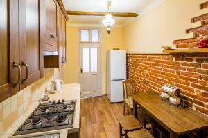 eine Küche mit einem Tisch und einem weißen Kühlschrank in der Unterkunft Apartment Krakivska 15 in Lwiw