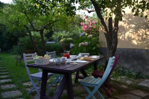 a wooden table with chairs and a table with food on it at B&B VELARDI in Viagrande