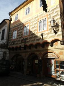 ein Gebäude mit einem Torbogen vor einem Geschäft in der Unterkunft Apartmán Latrán 15 in Český Krumlov