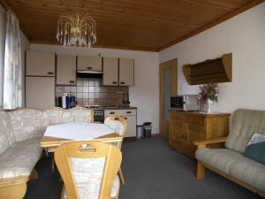 eine Küche und ein Wohnzimmer mit einem Tisch und einem Sofa in der Unterkunft Ferienhaus Sonja in Lindberg