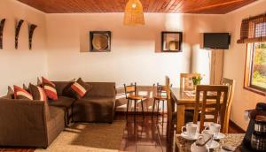 een woonkamer met een bank en een tafel bij Cabañas Boutique il Bosco in Algarrobo