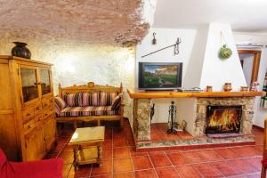 sala de estar con sofá y chimenea en Casa Rural La Herradura del río Júcar, en Jorquera