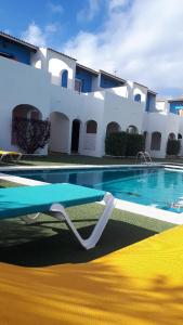 einem Pool mit einem Tisch vor einem Gebäude in der Unterkunft Apartamentos Ses Orenetes in Cala en Blanes