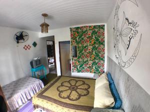 a small bedroom with a bed and a rug on the wall at Pousada Tia Cleide in Caraguatatuba +49 photos