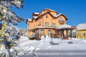a large house with snow on the ground at Vila Romantika in Zlatibor