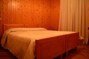a bedroom with a wooden bed with a wooden dresser at Albergo - B&B Alpina in Valdidentro +29 photos