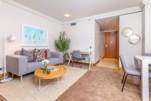 een woonkamer met een bank en een tafel bij Stylish Central City Apartment with Pool and Gym in Auckland