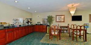 a dining room with a table and chairs and a kitchen at Americas Best Value Inn Hazlehurst in Hazlehurst