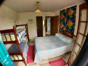 a bedroom with two bunk beds and a mirror at Pousada Tia Cleide in Caraguatatuba