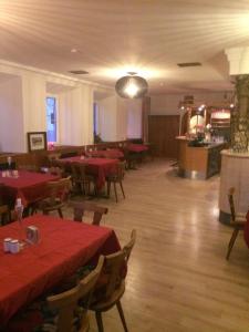 a restaurant with tables and chairs with red tablecloths at Gasthof Sonne Häselgehr in Häselgehr