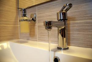 a bathroom sink with a faucet with water coming out at To Spiti - Pelion House in Kala Nera +65 photos