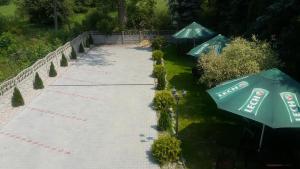 Una pasarela con dos sombrillas verdes. en Route One - Restauracja & Pokoje Hotelowe, en Zgierz
