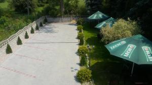 a walkway with two green umbrellas on it at Route One - Restauracja & Pokoje Hotelowe in Zgierz
