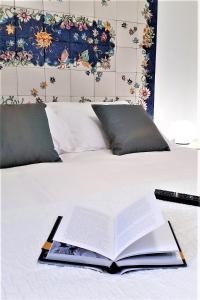 an open book on a bed with a remote control at La Corte dei Naviganti B&B - Amalfi Coast - Cetara in Cetara
