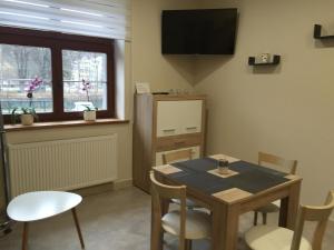a dining room with a table and chairs and a window at Apartament Nina in Wisła