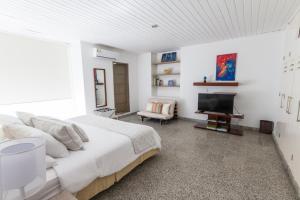 a white bedroom with a large bed and a television at Apartamento Vip Edificio Calima in San Andrés