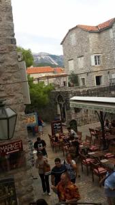 a group of people standing and sitting outside a building at Apartment Viva in Budva