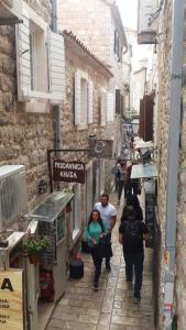 a group of people walking down a narrow street at Apartment Viva in Budva