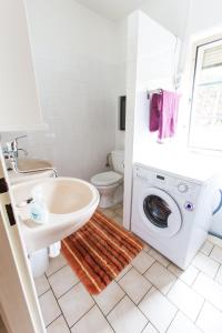 ein Badezimmer mit einem Waschbecken und einer Waschmaschine in der Unterkunft Lipno Family Cottage in Lipno nad Vltavou