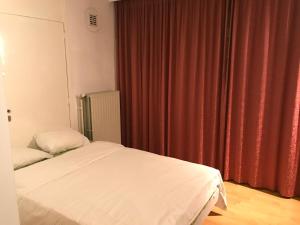 
a bedroom with a white bed and white curtains at Apartment Zaventem Brussels Airport C in Zaventem
