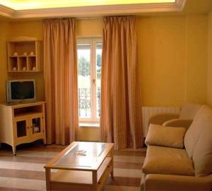 uma sala de estar com um sofá e uma mesa de centro em Apartamentos Villa de Noja em Noja
