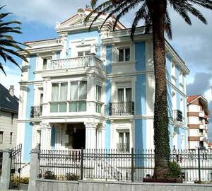 ノハにあるApartamentos Villa de Nojaのヤシの木が目の前に広がる青白の家