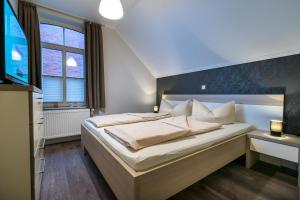 sypialnia z dużym łóżkiem i oknem w obiekcie Altstadt Wohnung 4 "Bant" w mieście Borkum