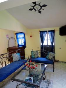 een woonkamer met een blauwe bank en een glazen tafel bij Casa Rincon Colonial in Tlalpujahua de Rayón