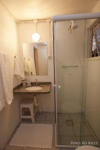 y baño con ducha, lavabo y aseo. en Pousada Casa de Praia, en Florianópolis