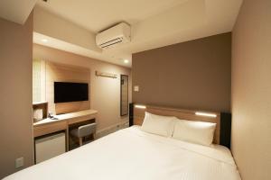Postel nebo postele na pokoji v ubytování Sotetsu Fresa Inn Tokyo Kanda