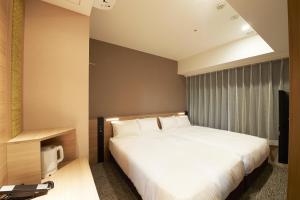 a bedroom with a white bed and a television at Sotetsu Fresa Inn Tokyo Kanda in Tokyo