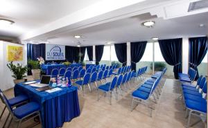 a conference room with blue tables and chairs and windows at Hotel Du Soleil in Rimini
